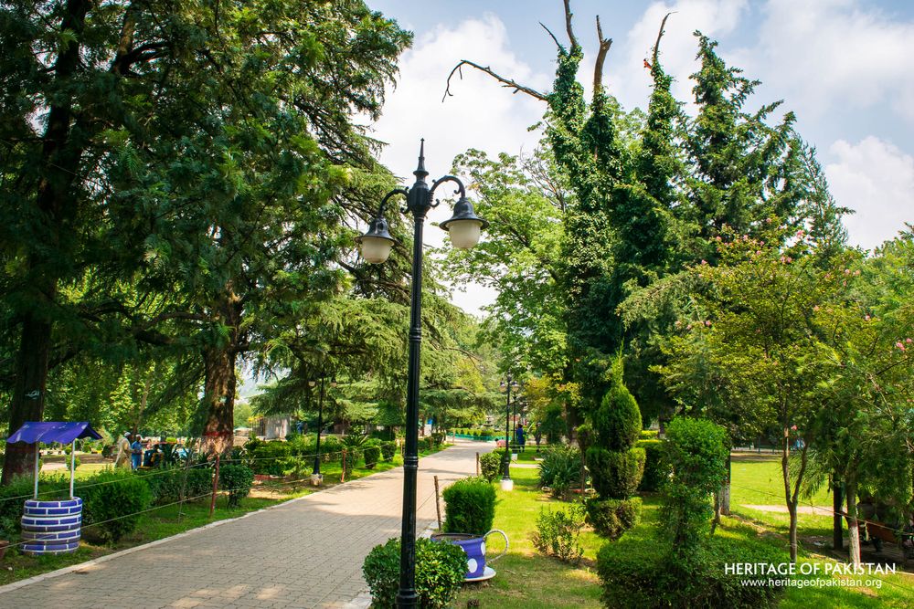 Columnar evergreens and period lamp posts line this heritage park's main avenue.